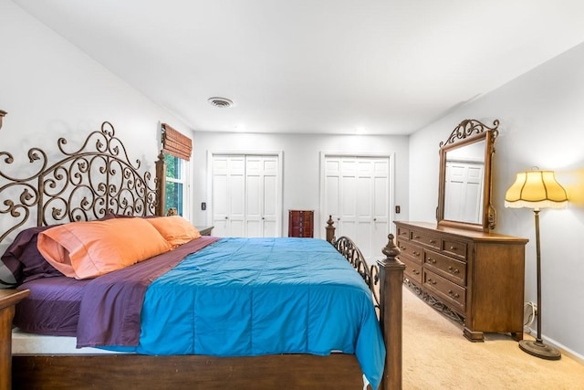 carpeted bedroom featuring two closets