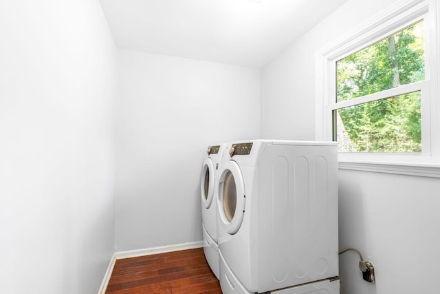 clothes washing area with washing machine and dryer and dark wood-type flooring