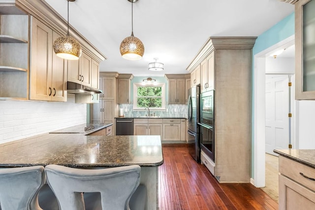 kitchen with dark wood-type flooring, pendant lighting, a breakfast bar area, light brown cabinetry, and black appliances