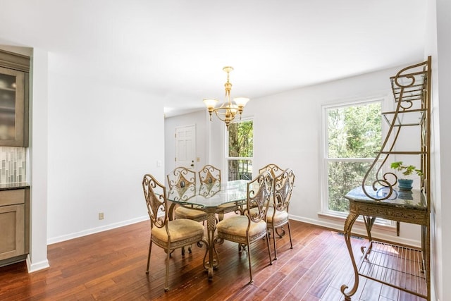 dining space featuring dark hardwood / wood-style flooring and an inviting chandelier