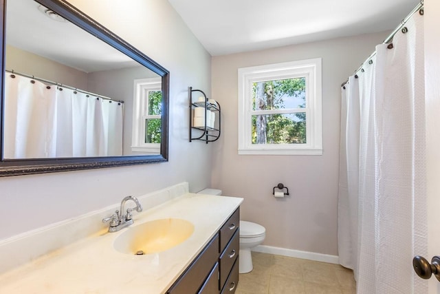 bathroom with tile patterned floors, vanity, toilet, and plenty of natural light