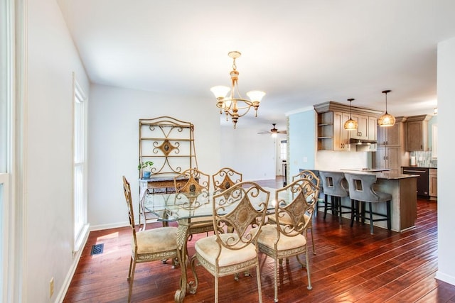 dining area featuring dark hardwood / wood-style flooring and ceiling fan with notable chandelier