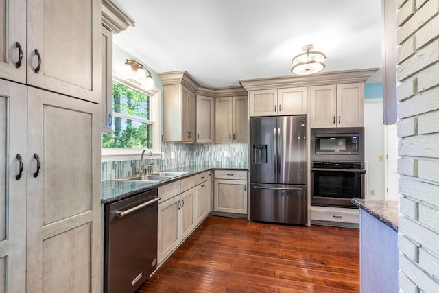 kitchen featuring decorative backsplash, dark hardwood / wood-style flooring, dark stone counters, sink, and black appliances