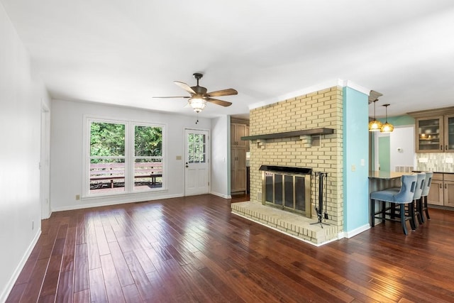 unfurnished living room with a fireplace, ceiling fan, and dark wood-type flooring