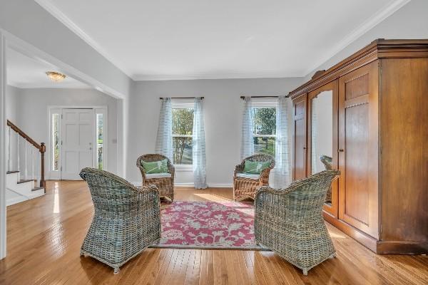 sitting room with hardwood / wood-style floors and ornamental molding