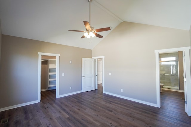 unfurnished bedroom with a walk in closet, ceiling fan, dark wood-type flooring, high vaulted ceiling, and a closet