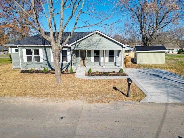 ranch-style house featuring covered porch and a storage unit