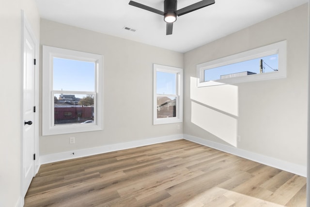 spare room with ceiling fan, a healthy amount of sunlight, and wood-type flooring