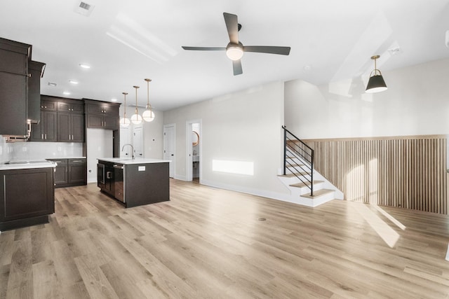 kitchen with a center island with sink, light hardwood / wood-style flooring, ceiling fan, and sink