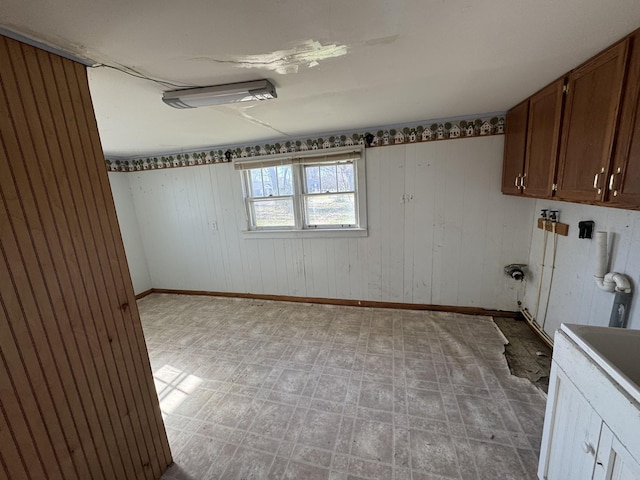 unfurnished room featuring wood walls