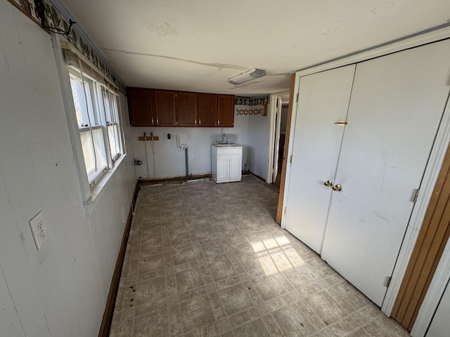 clothes washing area with cabinets