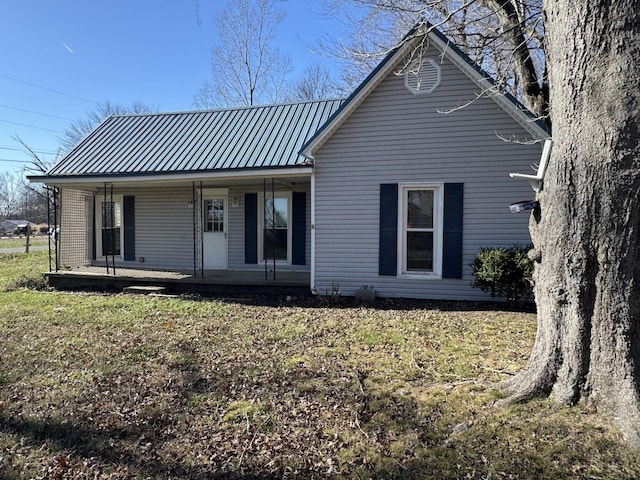 rear view of property featuring a porch and a yard