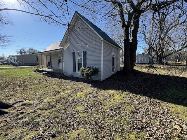 1200 N Church St, Portland, TN 37148 - view of side of home with a metal roof, a shed, and a porch