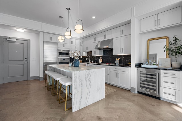 kitchen featuring white cabinets, pendant lighting, and wine cooler