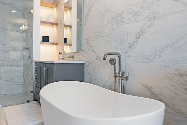 bathroom with vanity, separate shower and tub, and tile walls