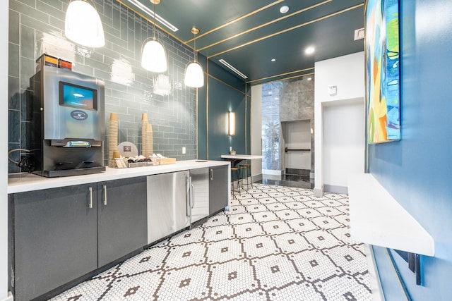 kitchen featuring decorative light fixtures, stainless steel refrigerator, and tile walls