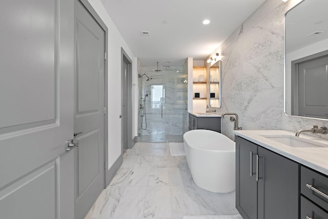 bathroom featuring shower with separate bathtub, vanity, and tile walls