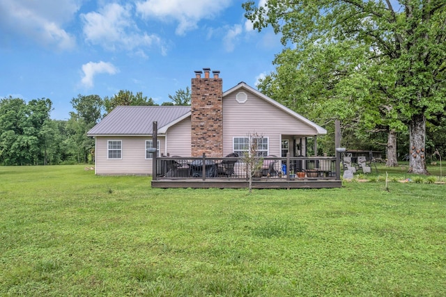 rear view of house featuring a lawn and a deck