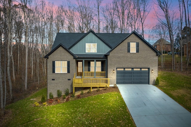 view of front of home featuring a lawn, covered porch, and a garage