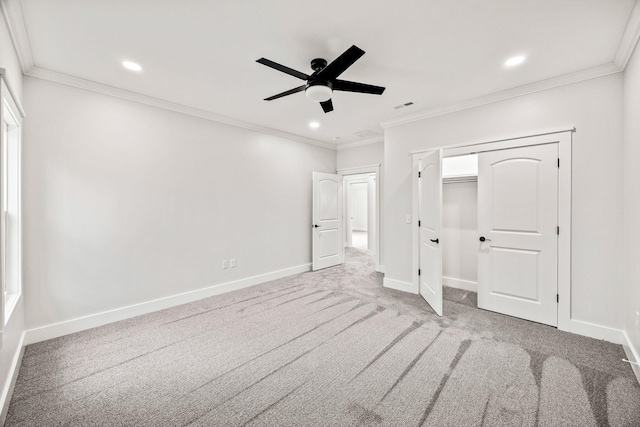 unfurnished bedroom featuring carpet flooring, a closet, ceiling fan, and crown molding