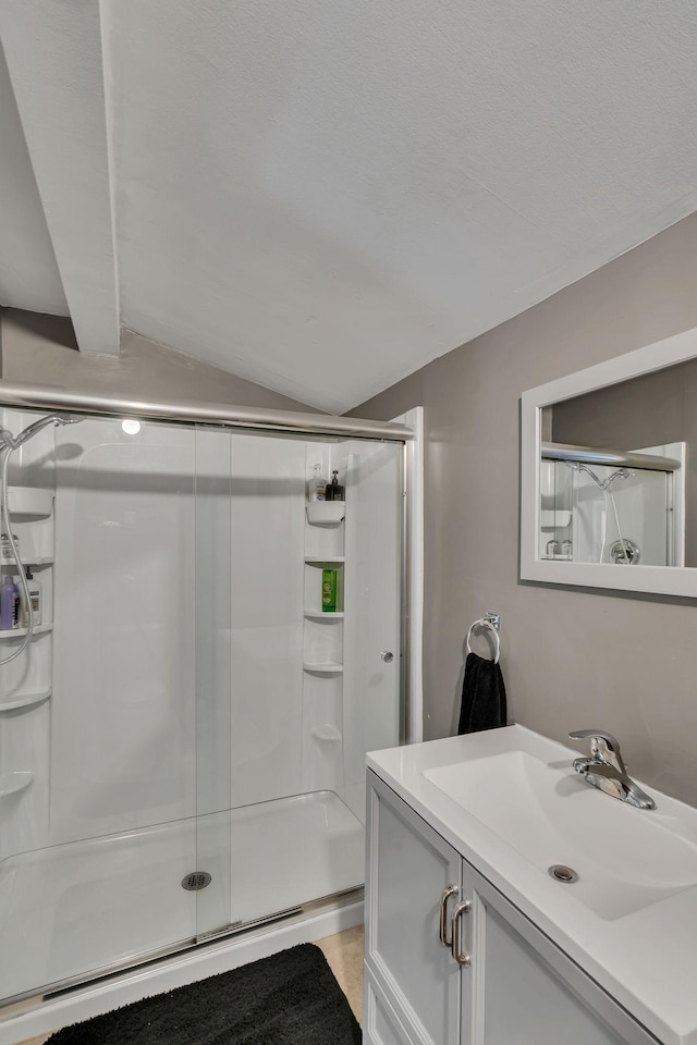 bathroom with vaulted ceiling with beams, vanity, and a shower with shower door