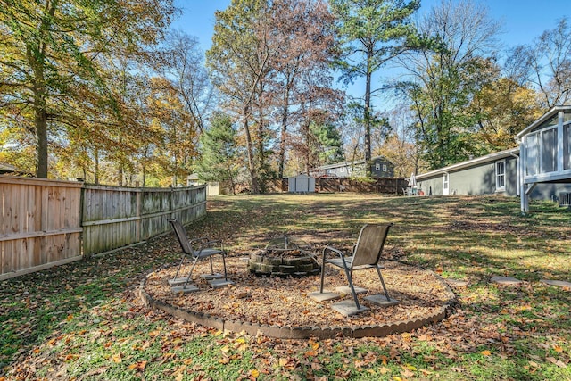 view of yard featuring a fire pit and a storage shed