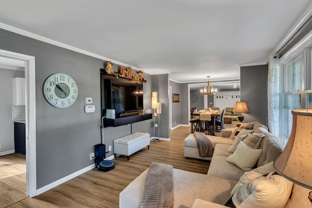 living room with a notable chandelier, wood-type flooring, and crown molding