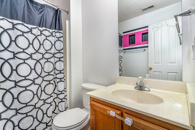 bathroom with curtained shower, vanity, a textured ceiling, and toilet