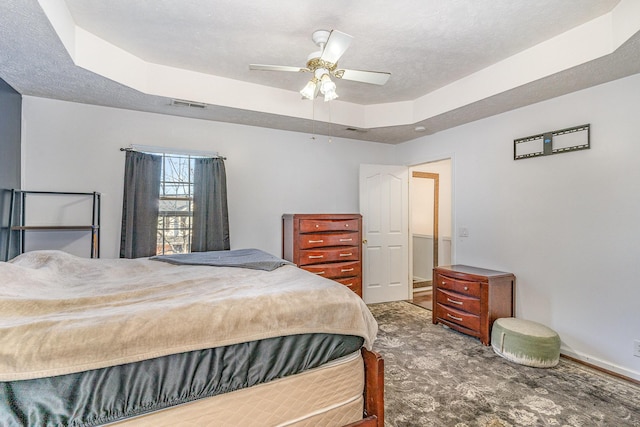 bedroom with ceiling fan and a tray ceiling