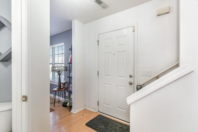 foyer entrance featuring a textured ceiling and light hardwood / wood-style floors