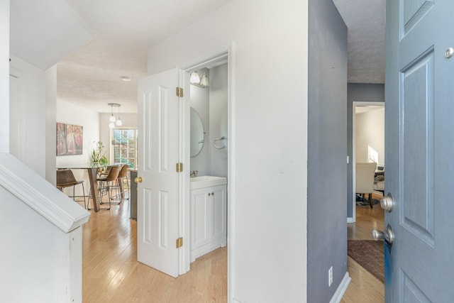 corridor featuring light hardwood / wood-style flooring and a textured ceiling