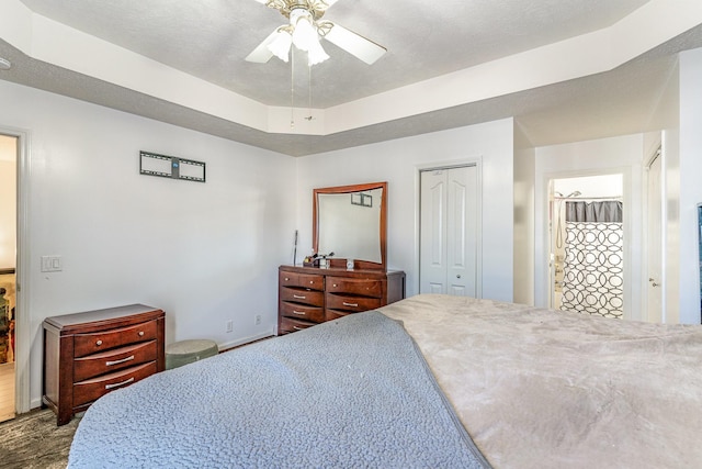 bedroom with a closet, a raised ceiling, and ceiling fan