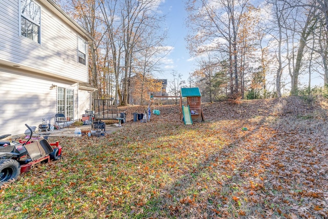 view of yard featuring a playground and a patio