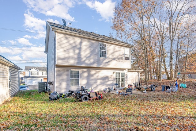 rear view of house with a lawn, cooling unit, and a patio area