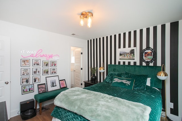 bedroom with hardwood / wood-style flooring and ensuite bath