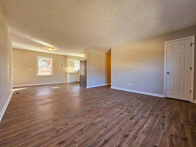 unfurnished living room with dark wood-type flooring and a textured ceiling