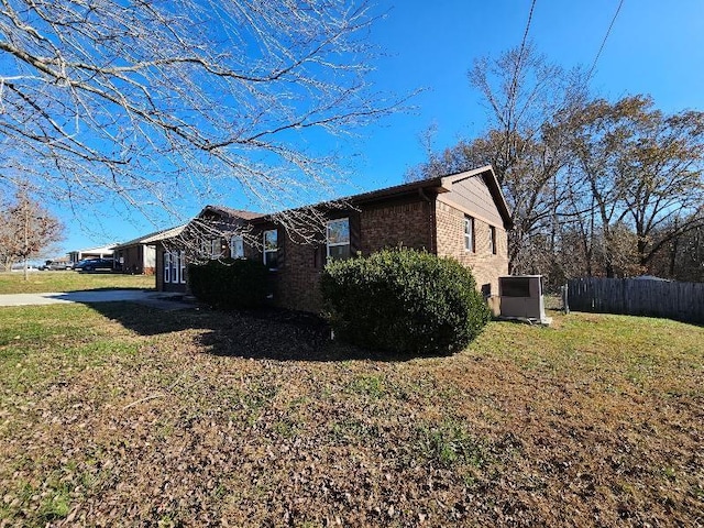 view of side of property featuring a yard and cooling unit