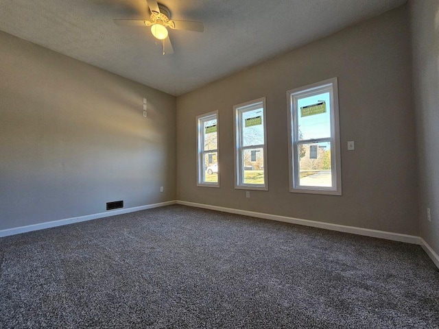 carpeted spare room featuring ceiling fan and a textured ceiling