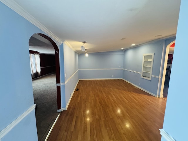 empty room with hardwood / wood-style flooring and crown molding