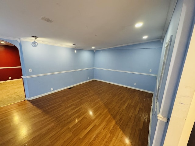 empty room featuring hardwood / wood-style flooring and crown molding