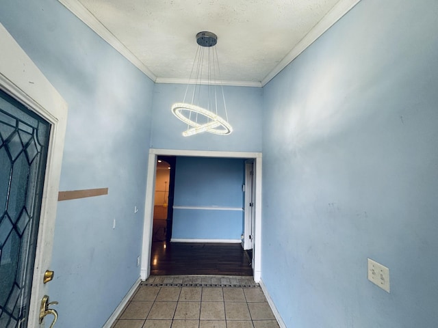 interior space with a chandelier, dark tile patterned flooring, and ornamental molding