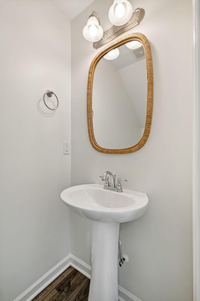 bathroom with baseboards and wood finished floors