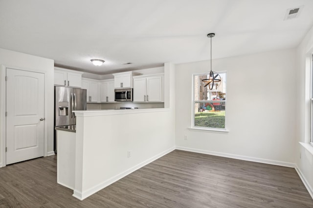 kitchen with pendant lighting, white cabinets, stainless steel appliances, and dark hardwood / wood-style floors