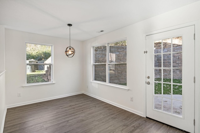 unfurnished dining area featuring dark wood-type flooring