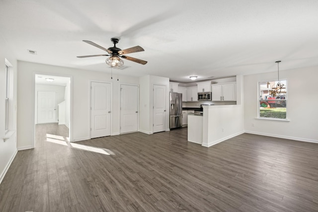 unfurnished living room with dark hardwood / wood-style flooring and ceiling fan