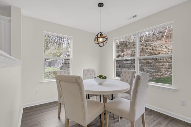 dining room featuring plenty of natural light, wood finished floors, and visible vents