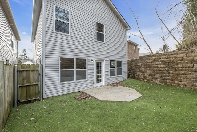 back of house featuring a lawn, a patio area, and a fenced backyard