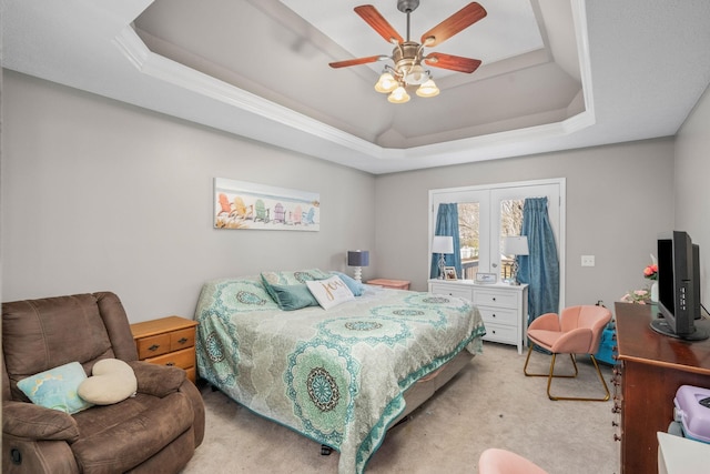 bedroom with ceiling fan, a tray ceiling, and light colored carpet