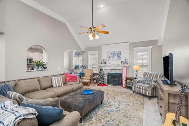 carpeted living room featuring ceiling fan, plenty of natural light, high vaulted ceiling, and a fireplace