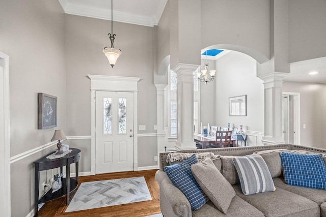 entryway with hardwood / wood-style flooring, crown molding, and a chandelier